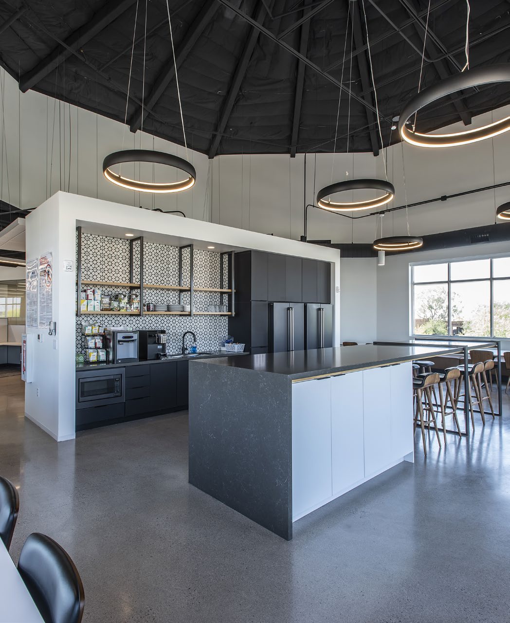 Common-area kitchen with vaulted ceiling and ring pendants