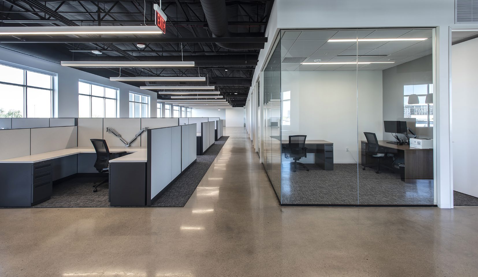 Open office floor with private glass-walled offices and abundant natural light